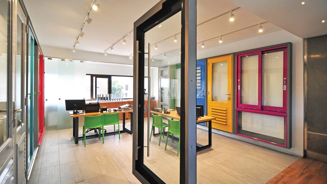 Air Master showroom displaying impact doors and windows in multiple aluminum finishes