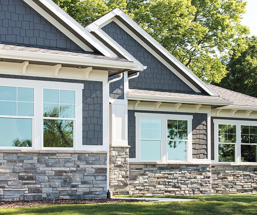 Pella windows set in stone and shingle siding.